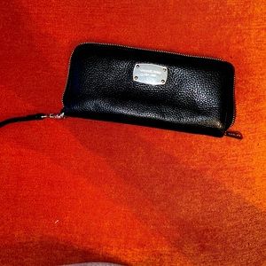 Black Michael Kors wallet with wristlet strap.